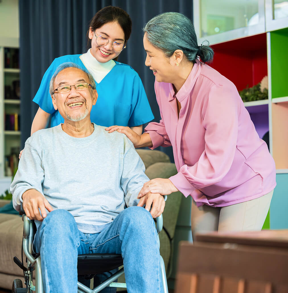 Caregiver and elderly man smiling together at home